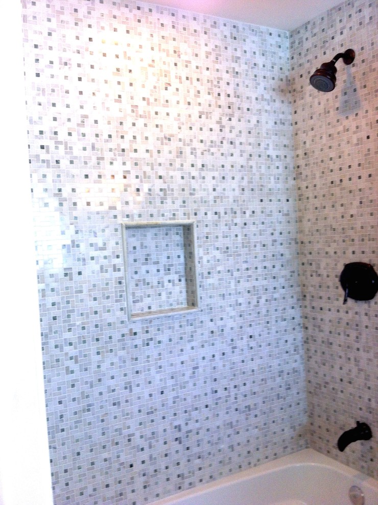 Cette image montre une grande salle d'eau traditionnelle en bois foncé avec un placard avec porte à panneau surélevé, une baignoire en alcôve, un combiné douche/baignoire, WC à poser, un carrelage noir, un carrelage blanc, mosaïque, un mur blanc, un sol en carrelage de céramique, un lavabo posé et un plan de toilette en carrelage.