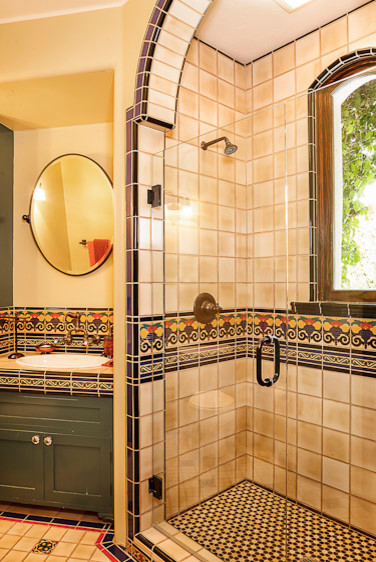 Idéer för mellanstora medelhavsstil en-suite badrum, med en dusch i en alkov, flerfärgad kakel, gula väggar och ett integrerad handfat