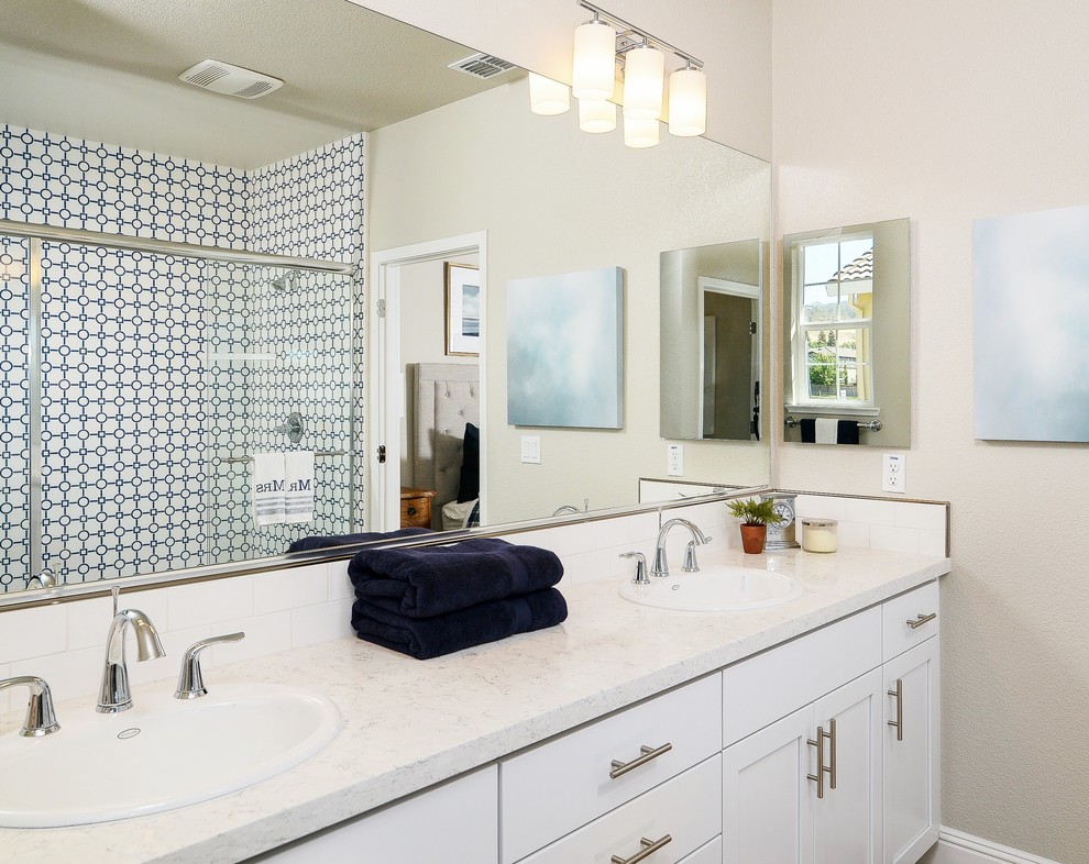 Design ideas for a medium sized beach style ensuite bathroom in Sacramento with shaker cabinets, white cabinets, a shower/bath combination, a one-piece toilet, white tiles, metro tiles, beige walls, porcelain flooring, a built-in sink and engineered stone worktops.