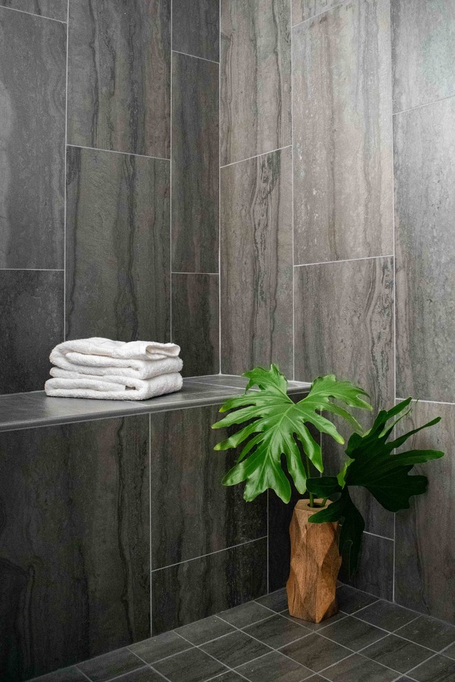 Example of a mid-sized minimalist master gray tile and porcelain tile porcelain tile and gray floor alcove shower design in San Francisco with flat-panel cabinets, blue cabinets, a one-piece toilet, gray walls, an undermount sink, quartz countertops, a hinged shower door and white countertops
