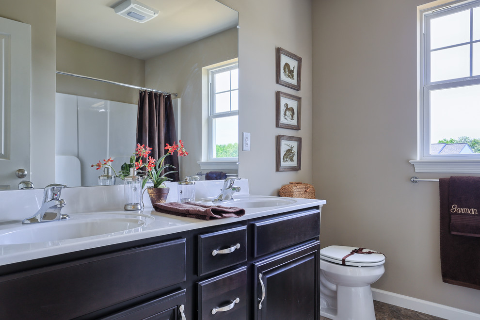 Bathroom - large traditional linoleum floor bathroom idea in Philadelphia with raised-panel cabinets, dark wood cabinets, a two-piece toilet, beige walls and an integrated sink