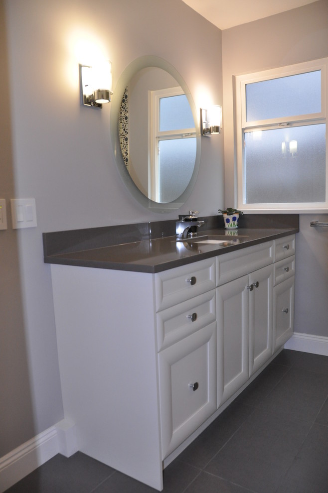 Modelo de cuarto de baño minimalista de tamaño medio con lavabo bajoencimera, armarios con paneles lisos, puertas de armario blancas, encimera de cuarcita y aseo y ducha