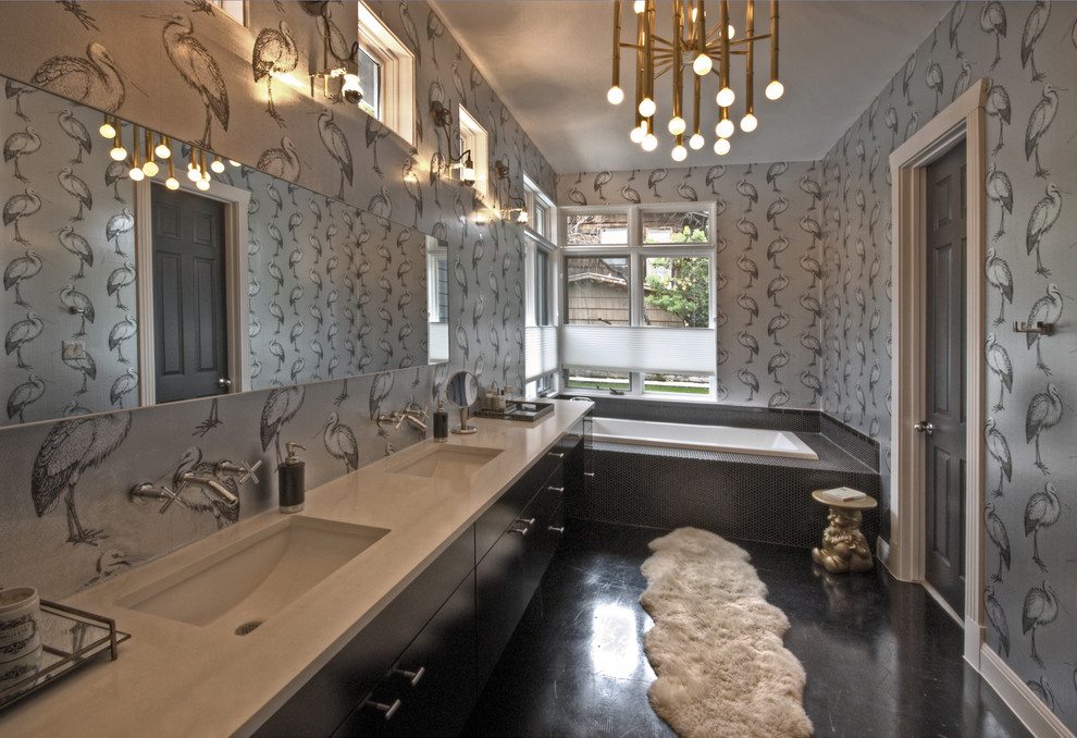 Cette photo montre une salle de bain moderne avec une baignoire en alcôve, un carrelage noir et un mur gris.