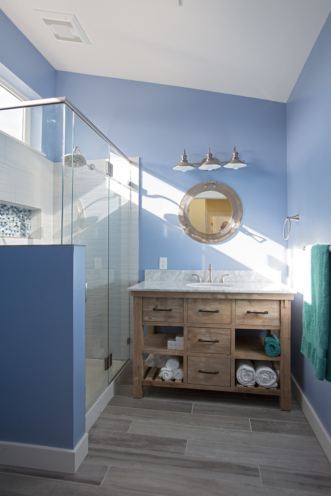 Photo of a small ensuite bathroom in Seattle with a corner shower, blue walls, grey floors and a hinged door.