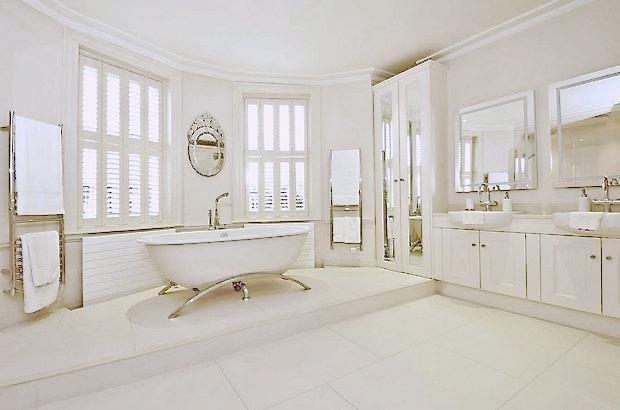 Cette photo montre une très grande salle de bain principale tendance avec une baignoire indépendante et un sol en calcaire.