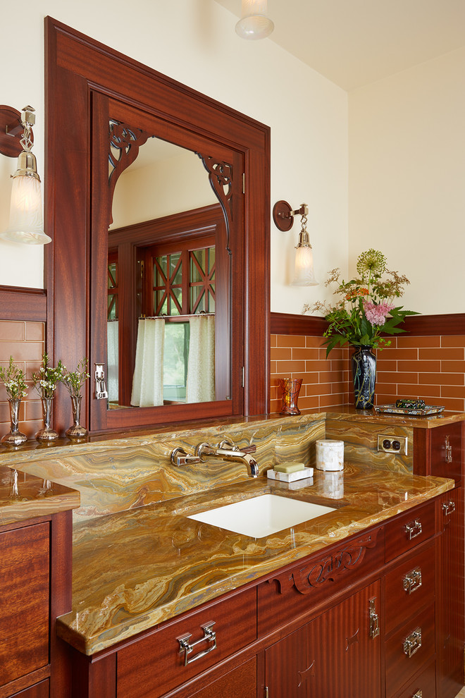 Cette image montre une salle de bain principale craftsman en bois brun avec un lavabo encastré, un mur blanc, un placard à porte plane, un plan de toilette en granite, un carrelage orange et un carrelage métro.
