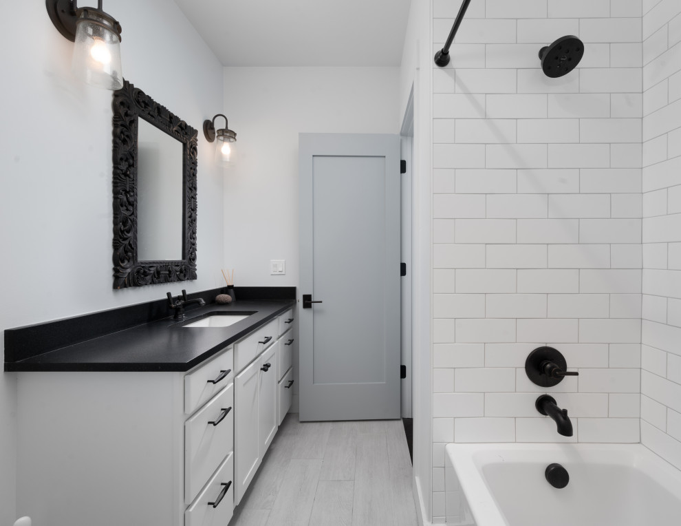 Idéer för mellanstora rustika svart badrum, med vita skåp, ett badkar i en alkov, en dusch/badkar-kombination, vit kakel, vita väggar, laminatgolv, ett undermonterad handfat, grått golv och dusch med duschdraperi