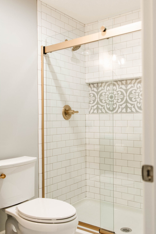 Photo of a small traditional shower room bathroom in Omaha with freestanding cabinets, grey cabinets, an alcove shower, a two-piece toilet, white tiles, metro tiles, beige walls, a submerged sink, marble worktops, white floors, a sliding door and white worktops.