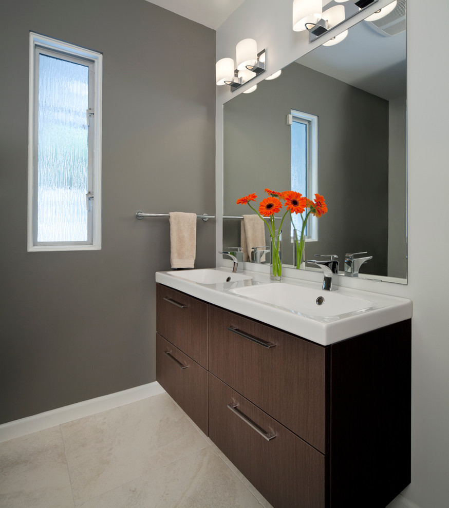 Imagen de cuarto de baño contemporáneo con lavabo integrado, armarios con paneles lisos, puertas de armario de madera en tonos medios y baldosas y/o azulejos beige