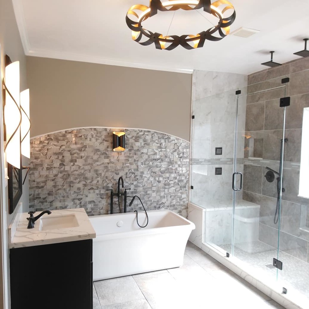 Inspiration for a medium sized contemporary ensuite bathroom in Houston with raised-panel cabinets, grey cabinets, a freestanding bath, a double shower, a bidet, grey tiles, porcelain tiles, grey walls, porcelain flooring, a submerged sink, granite worktops, grey floors, a hinged door and white worktops.