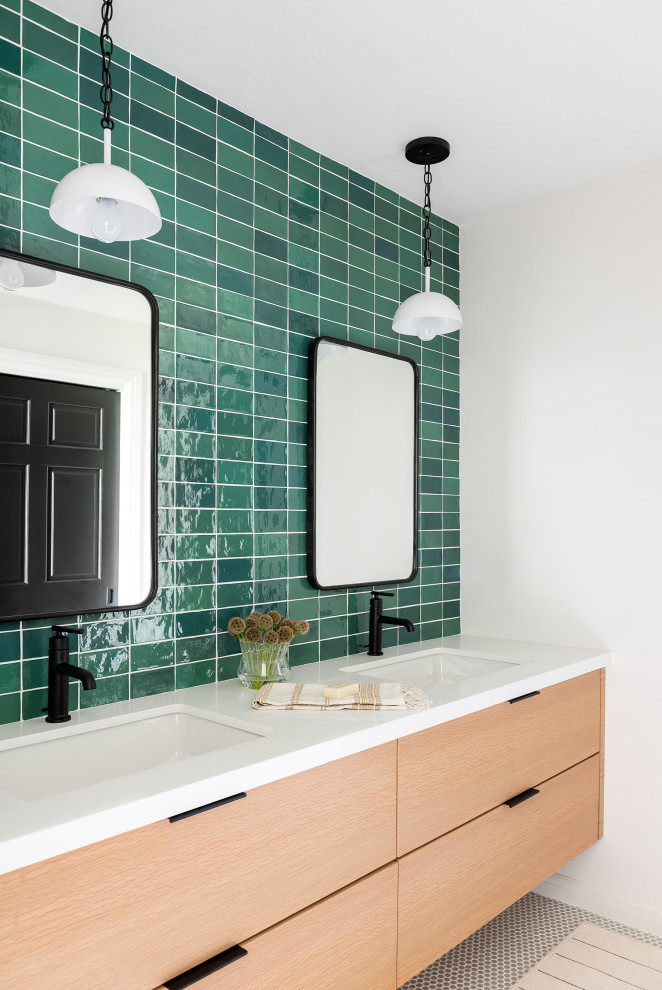 Пример оригинального дизайна: ванная комната в современном стиле с плоскими фасадами, светлыми деревянными фасадами, зеленой плиткой, плиткой кабанчик, белыми стенами, полом из мозаичной плитки, врезной раковиной, серым полом, белой столешницей, тумбой под две раковины и подвесной тумбой