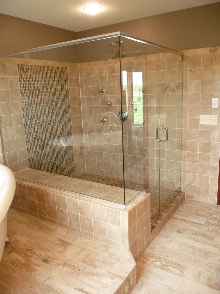Cette image montre une grande salle de bain principale méditerranéenne avec une douche d'angle, un placard avec porte à panneau encastré, des portes de placard noires, une baignoire sur pieds, WC à poser, un carrelage beige, des carreaux de céramique, un mur beige, un sol en carrelage de céramique, un lavabo encastré, un plan de toilette en granite, un sol beige et une cabine de douche à porte battante.