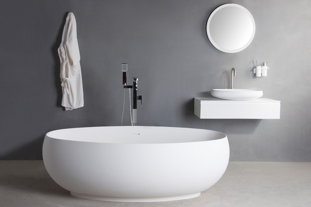 Inspiration för ett funkis en-suite badrum, med ett fristående badkar och bänkskiva i akrylsten