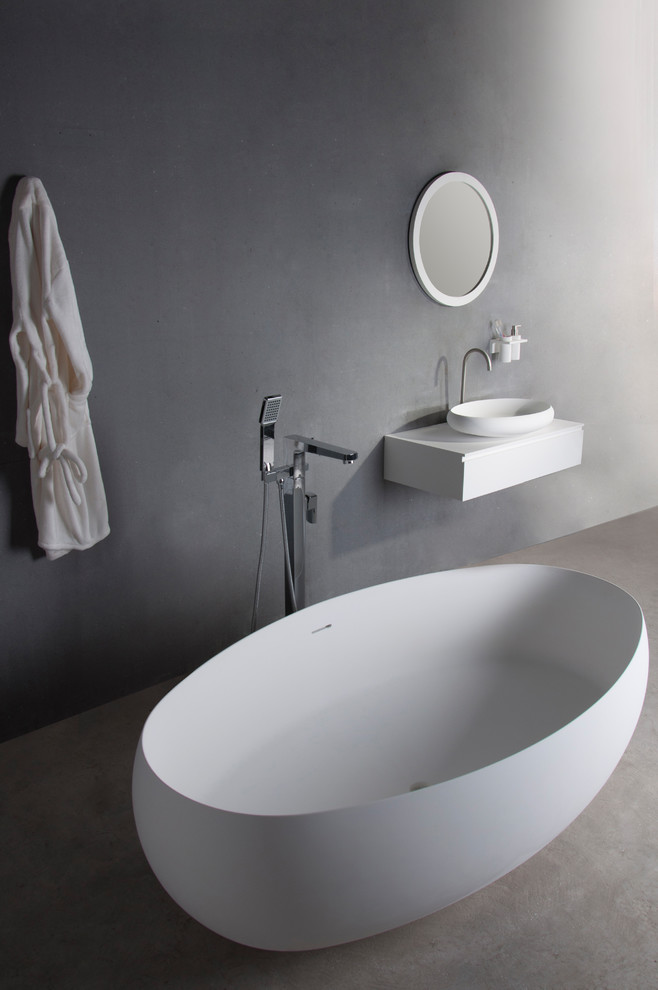 На фото: главная ванная комната в современном стиле с отдельно стоящей ванной и столешницей из искусственного камня