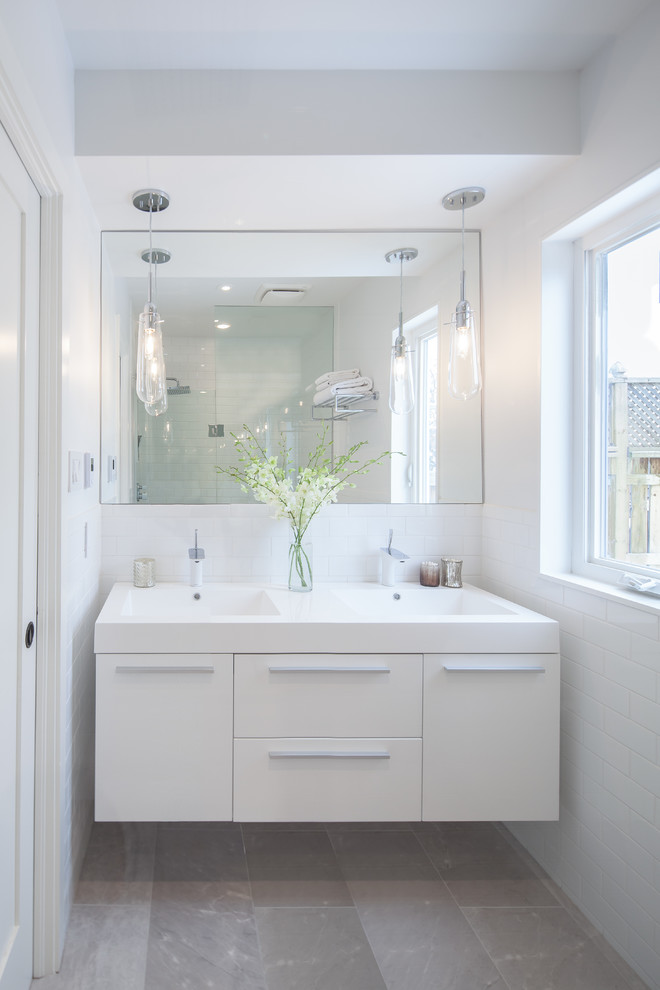 Ejemplo de cuarto de baño actual con armarios con paneles lisos, puertas de armario blancas y lavabo integrado