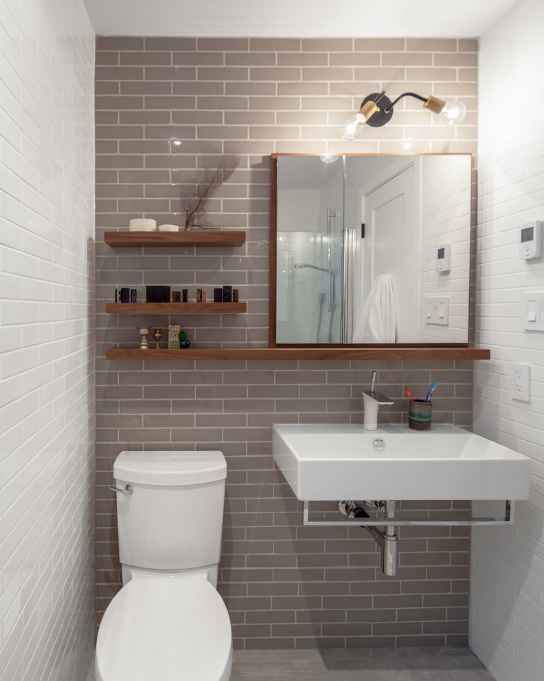 Immagine di una stanza da bagno contemporanea con lavabo sospeso e piastrelle grigie