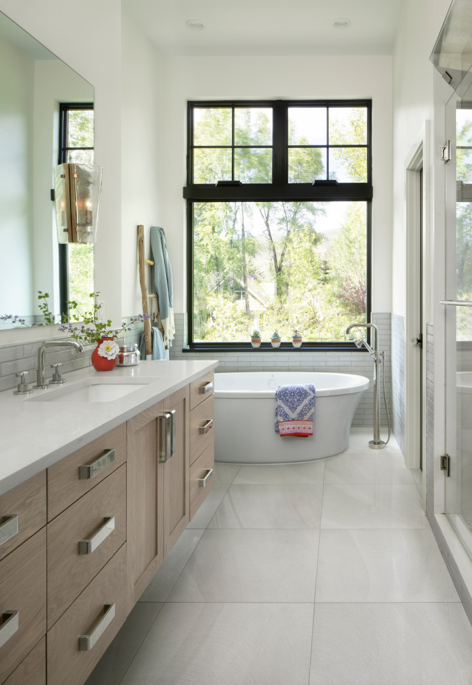 Inspiration for a farmhouse master gray tile gray floor freestanding bathtub remodel in Denver with shaker cabinets, light wood cabinets, white walls, an undermount sink, white countertops and a floating vanity
