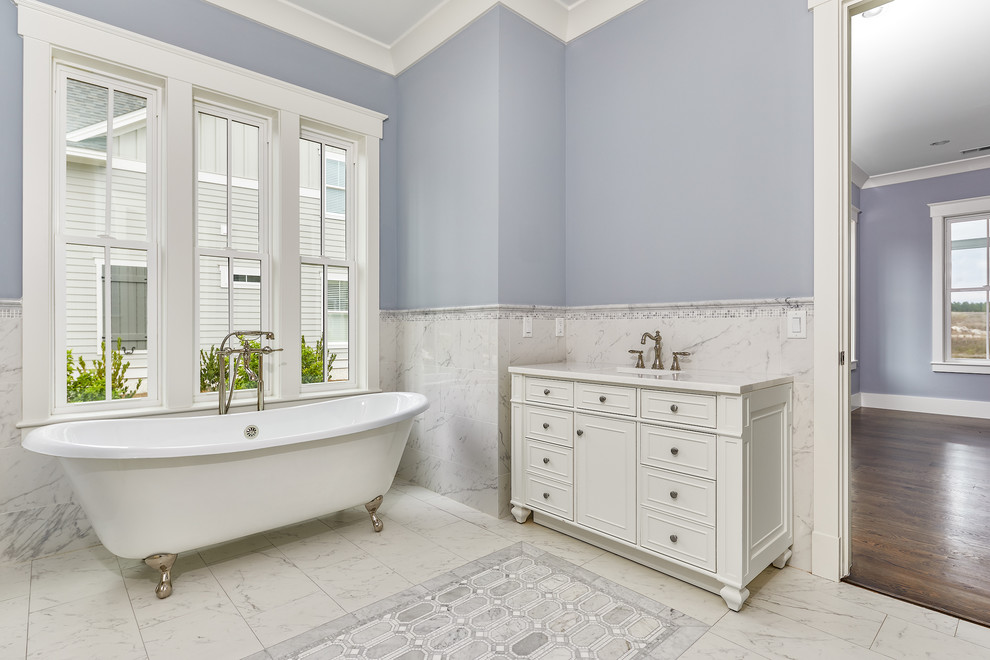 Bild på ett stort maritimt vit vitt en-suite badrum, med vit kakel, mosaik, blå väggar, mosaikgolv, ett nedsänkt handfat, bänkskiva i kvartsit, vitt golv och ett badkar med tassar