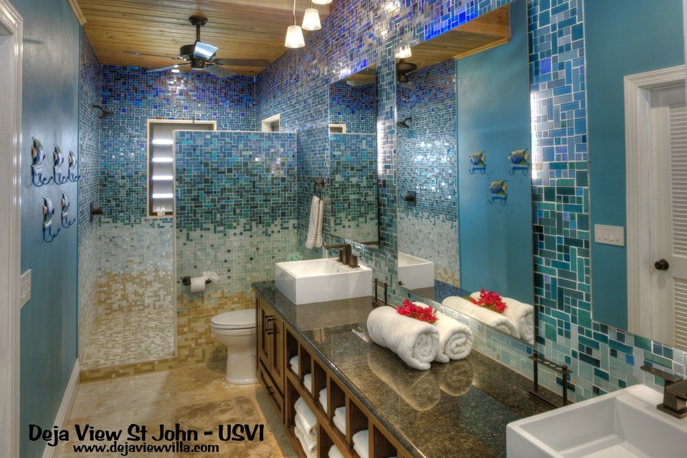 Foto de cuarto de baño principal marinero extra grande con armarios abiertos, puertas de armario de madera en tonos medios, ducha abierta, sanitario de pared, baldosas y/o azulejos azules, baldosas y/o azulejos de vidrio, paredes azules, lavabo sobreencimera y encimera de granito