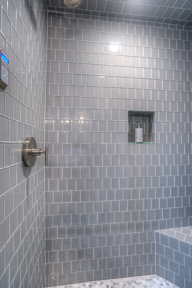 Ispirazione per una stanza da bagno moderna di medie dimensioni con ante a filo, ante grigie, vasca/doccia, piastrelle grigie, piastrelle di vetro, pareti grigie, pavimento in ardesia, lavabo integrato e top in quarzo composito