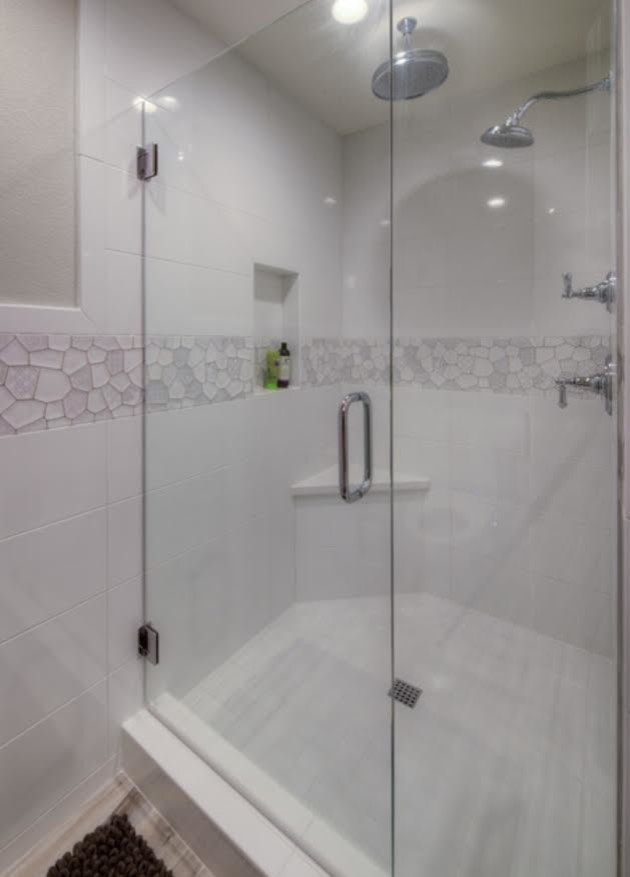 Example of a mid-sized transitional master white tile and ceramic tile porcelain tile and brown floor bathroom design in San Diego with shaker cabinets, white cabinets, brown walls, an undermount sink, solid surface countertops and a hinged shower door
