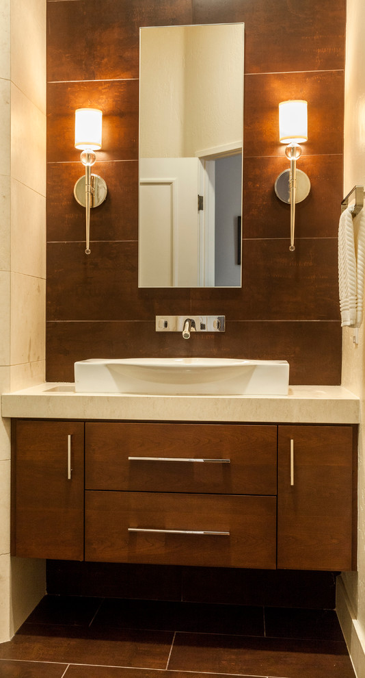 Cette image montre une petite salle d'eau design en bois foncé avec une vasque, un placard en trompe-l'oeil, un plan de toilette en calcaire, une douche d'angle, WC à poser, un carrelage beige, un carrelage de pierre, un mur beige et un sol en carrelage de porcelaine.