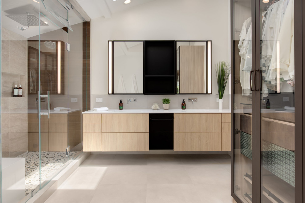 Design ideas for a medium sized contemporary ensuite bathroom in Tampa with flat-panel cabinets, light wood cabinets, a corner shower, a wall mounted toilet, beige tiles, porcelain tiles, white walls, porcelain flooring, a submerged sink, engineered stone worktops, beige floors, a hinged door and white worktops.