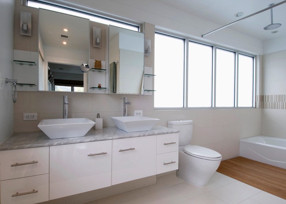 Esempio di una stanza da bagno padronale moderna con ante lisce, ante bianche, vasca ad alcova, doccia aperta, WC monopezzo, piastrelle beige, pareti bianche e lavabo a bacinella