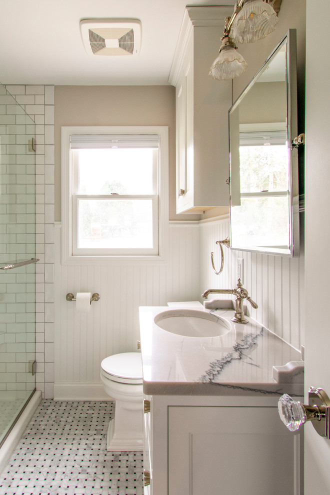 Idée de décoration pour une petite salle de bain principale tradition avec un placard à porte affleurante, des portes de placard grises, une douche d'angle, WC séparés, un carrelage blanc, un carrelage métro, un mur beige, un sol en marbre, un lavabo encastré, un plan de toilette en quartz, un sol gris, une cabine de douche à porte battante et un plan de toilette blanc.