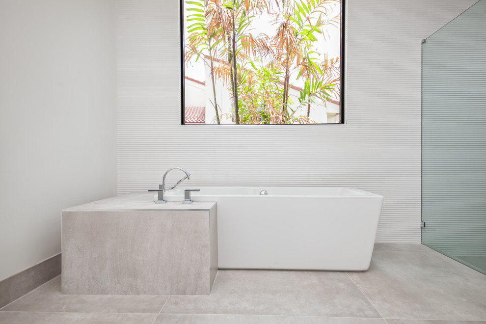 Bild på ett stort funkis vit vitt en-suite badrum, med släta luckor, grå skåp, ett fristående badkar, en kantlös dusch, vita väggar, betonggolv, ett nedsänkt handfat, marmorbänkskiva, grått golv och med dusch som är öppen