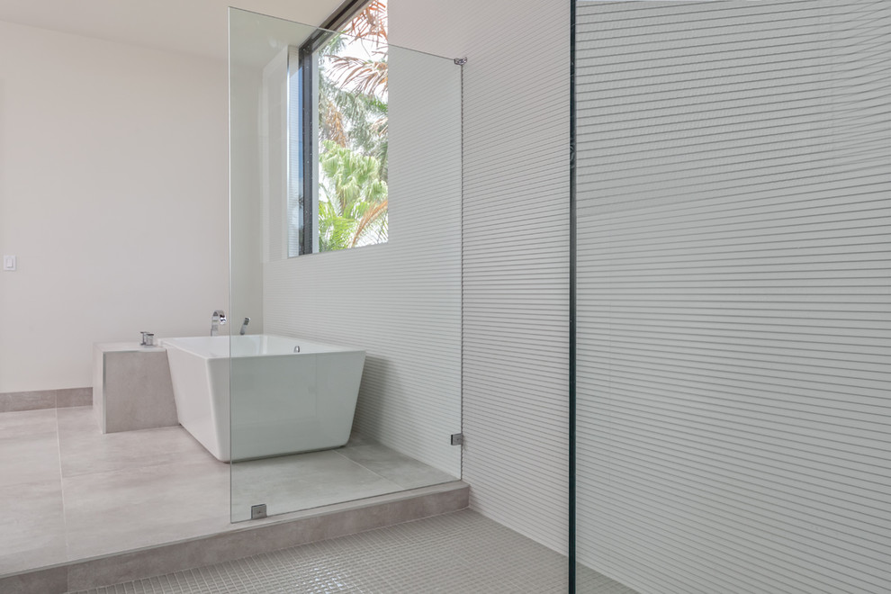 This is an example of a large modern ensuite bathroom in Miami with flat-panel cabinets, grey cabinets, a freestanding bath, a built-in shower, white walls, concrete flooring, a built-in sink, marble worktops, grey floors, an open shower and white worktops.