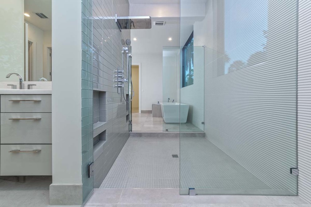 Inspiration for a large modern ensuite bathroom in Miami with flat-panel cabinets, grey cabinets, a freestanding bath, a built-in shower, white walls, concrete flooring, a built-in sink, marble worktops, grey floors, an open shower and white worktops.