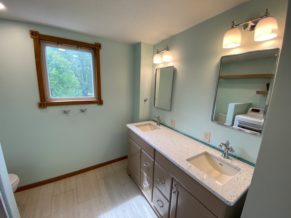 Photo of a medium sized traditional family bathroom in Columbus with shaker cabinets, brown cabinets, an alcove bath, a shower/bath combination, a two-piece toilet, beige tiles, porcelain tiles, green walls, porcelain flooring, a submerged sink, recycled glass worktops, beige floors, a hinged door, multi-coloured worktops, a wall niche, double sinks, a freestanding vanity unit and wallpapered walls.