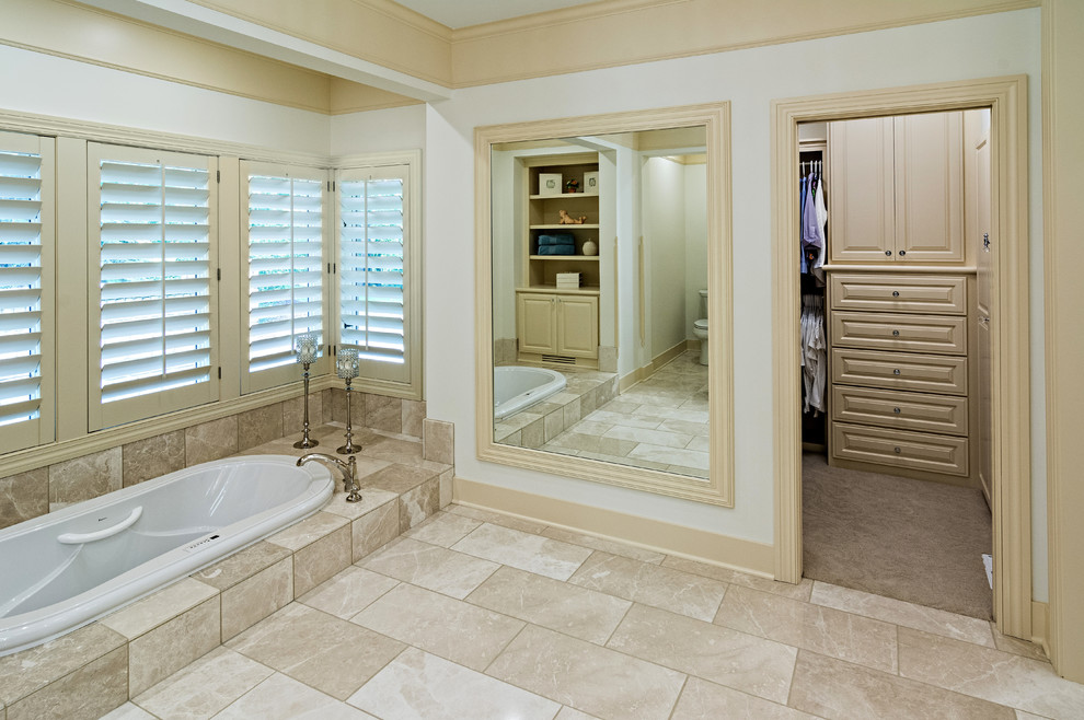 This is an example of a large classic ensuite bathroom in Minneapolis with raised-panel cabinets, white cabinets, a walk-in shower, white tiles, ceramic tiles, white walls, porcelain flooring, a submerged sink, granite worktops and a hot tub.