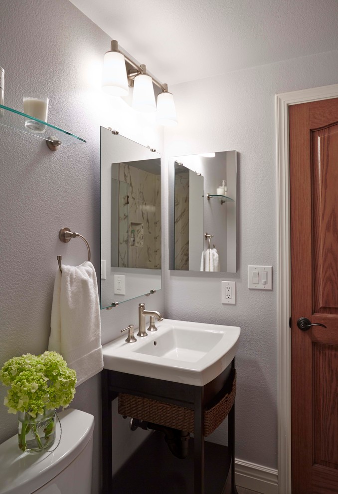 Inredning av ett modernt litet badrum med dusch, med ett väggmonterat handfat, möbel-liknande, skåp i mörkt trä, bänkskiva i akrylsten, en toalettstol med hel cisternkåpa, beige kakel, grå väggar och kalkstensgolv