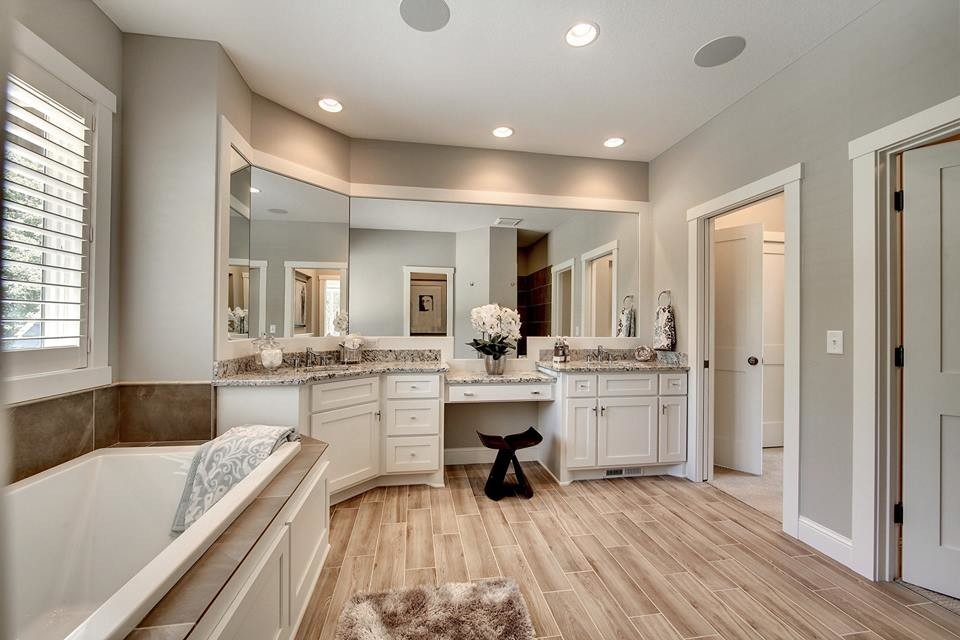 Klassisk inredning av ett badrum, med skåp i shakerstil, vita skåp, ett platsbyggt badkar, grå väggar, klinkergolv i porslin, ett undermonterad handfat och granitbänkskiva