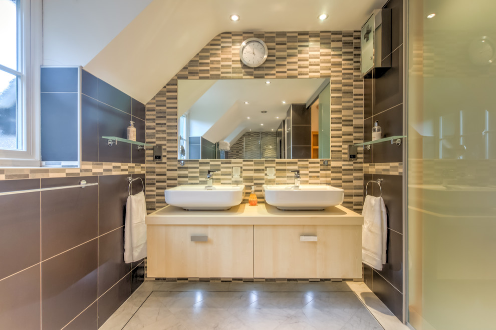This is an example of a medium sized contemporary bathroom in West Midlands with flat-panel cabinets, light wood cabinets, black walls, a wall-mounted sink and white floors.