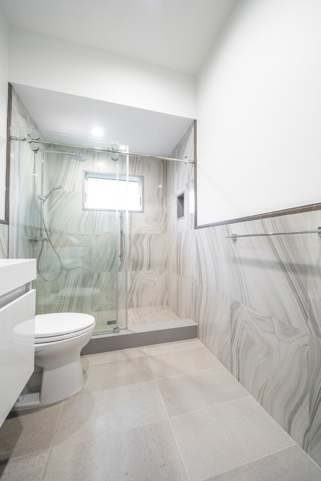 Idées déco pour une salle de bain éclectique avec un espace douche bain, WC à poser, un carrelage multicolore, des carreaux de porcelaine, un mur blanc, un sol en carrelage de porcelaine, un lavabo intégré, un sol gris et une cabine de douche à porte coulissante.