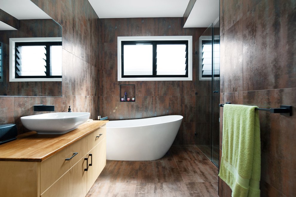 Idées déco pour une salle de bain moderne en bois clair avec un placard en trompe-l'oeil, une baignoire indépendante, une douche d'angle, un carrelage multicolore, une vasque et un plan de toilette en bois.