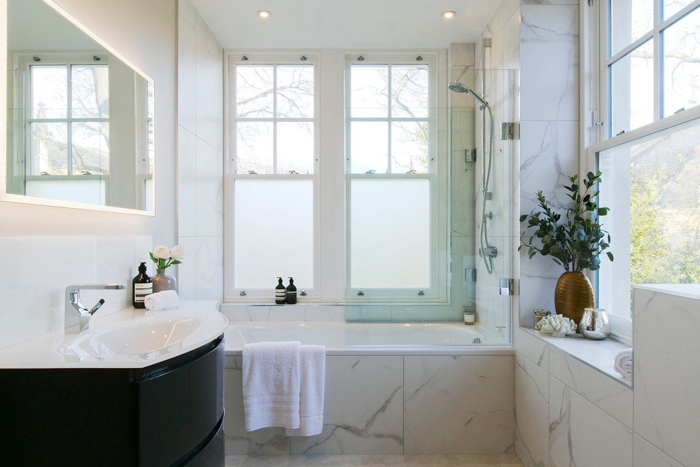 Example of a large transitional master white tile bathroom design in London with flat-panel cabinets, black cabinets, white walls, a drop-in sink and white countertops