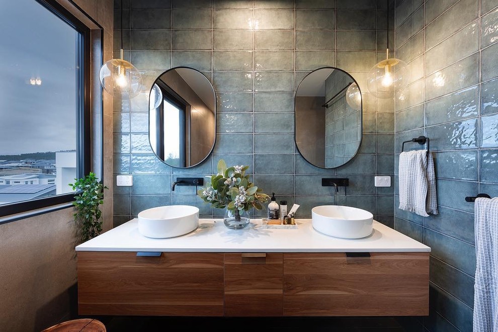 Diseño de cuarto de baño principal contemporáneo de tamaño medio con armarios con paneles lisos, puertas de armario de madera oscura, baldosas y/o azulejos grises, paredes beige, lavabo sobreencimera y encimeras blancas