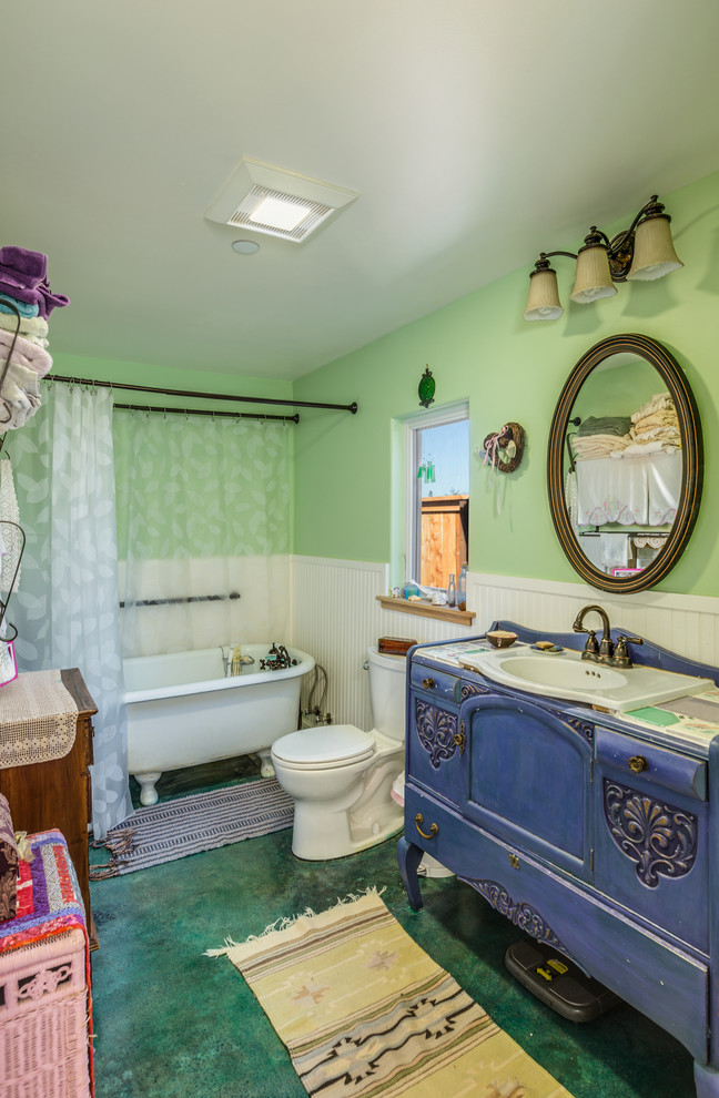 Réalisation d'une petite salle de bain principale bohème en bois foncé avec une vasque, un placard en trompe-l'oeil, une baignoire sur pieds, WC à poser, un mur vert et sol en béton ciré.