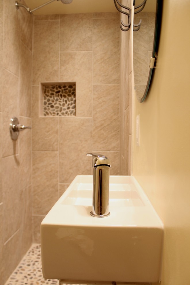 На фото: маленькая ванная комната в современном стиле с подвесной раковиной, угловым душем, раздельным унитазом, бежевой плиткой, керамической плиткой, желтыми стенами и полом из керамической плитки для на участке и в саду с