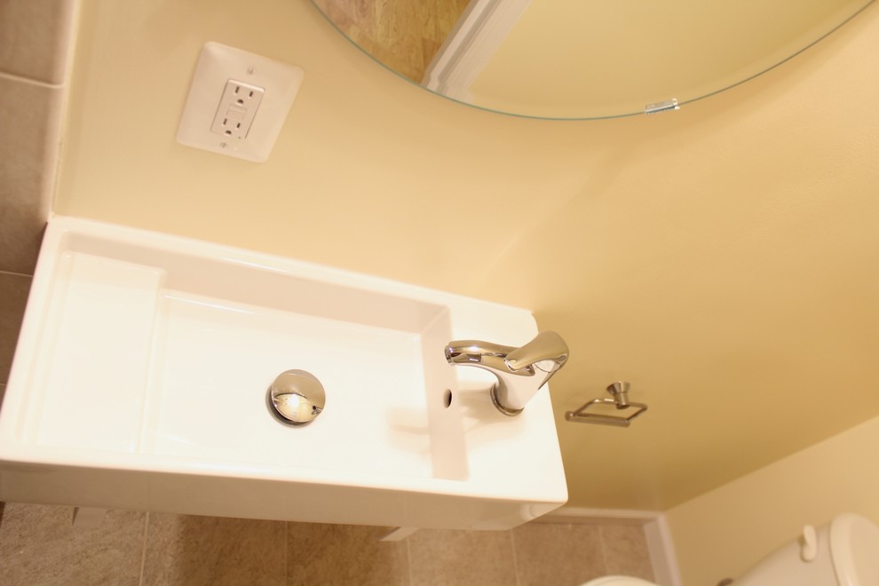 Идея дизайна: маленькая ванная комната в современном стиле с подвесной раковиной, угловым душем, раздельным унитазом, бежевой плиткой, керамической плиткой, желтыми стенами и полом из керамической плитки для на участке и в саду