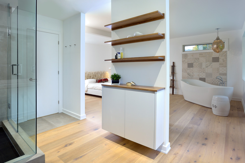 Idéer för ett mellanstort modernt en-suite badrum, med öppna hyllor, skåp i mellenmörkt trä, ett fristående badkar, vita väggar, plywoodgolv, träbänkskiva och brunt golv