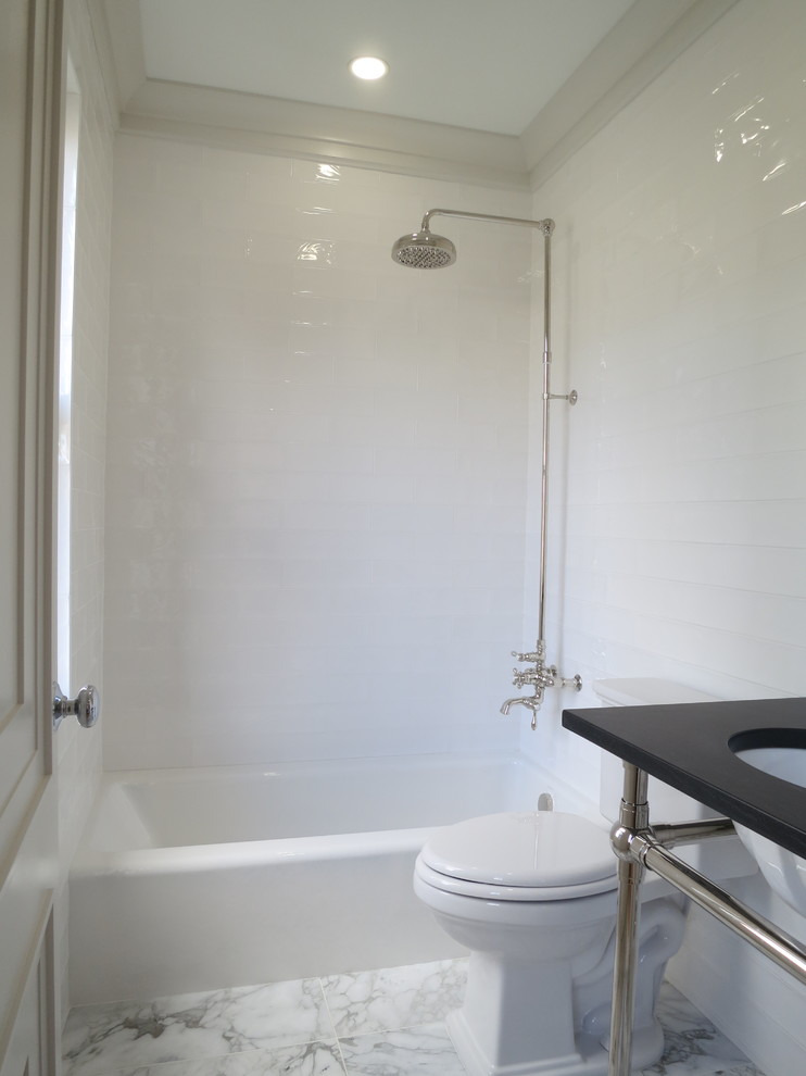 Inspiration for a medium sized classic ensuite bathroom in DC Metro with an alcove bath, a shower/bath combination, a two-piece toilet, white tiles, ceramic tiles, white walls, ceramic flooring, a submerged sink, solid surface worktops, an open shower and white floors.