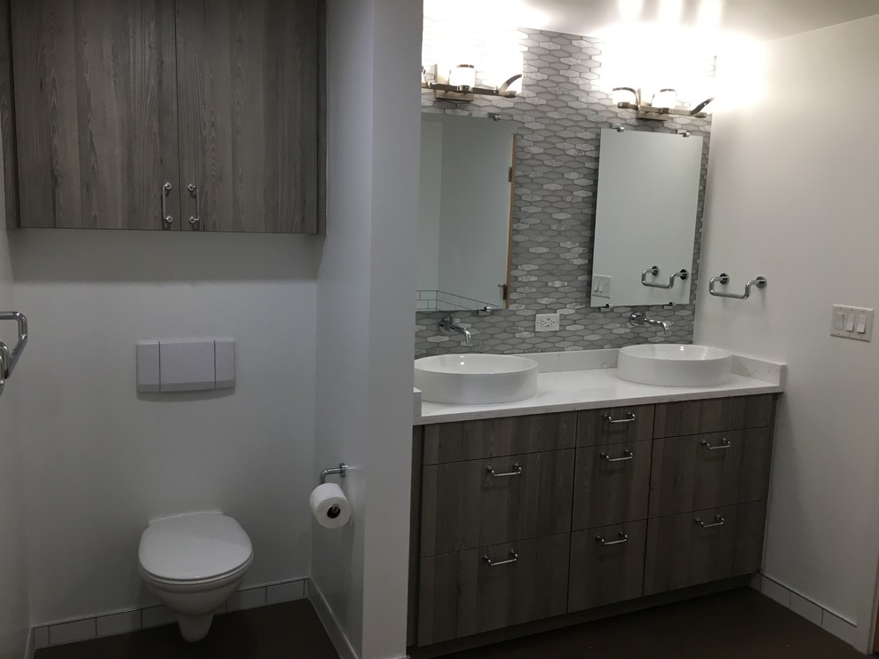 Inspiration for a mid-sized industrial master white tile and subway tile mosaic tile floor and gray floor corner shower remodel in Denver with flat-panel cabinets, gray cabinets, an undermount tub, a wall-mount toilet, white walls, a vessel sink, quartzite countertops and a hinged shower door