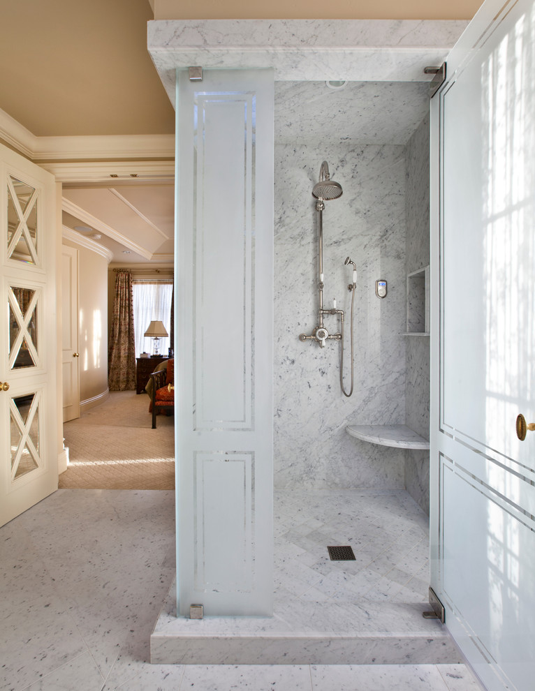 На фото: огромная главная ванная комната в классическом стиле с фасадами с выступающей филенкой, белыми фасадами, полновстраиваемой ванной, угловым душем, серой плиткой, плиткой из листового камня, бежевыми стенами, мраморным полом, врезной раковиной и мраморной столешницей с