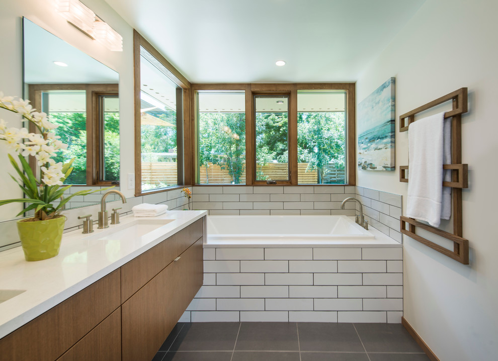 Cette image montre une salle de bain principale vintage en bois brun avec un carrelage blanc, un mur blanc et un plan de toilette en quartz modifié.