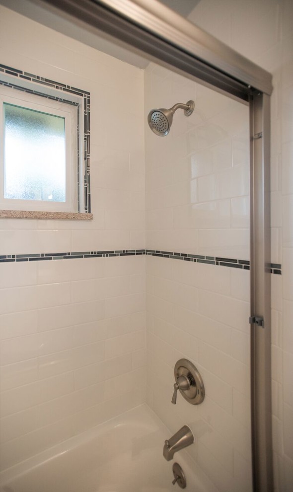 Cette image montre une salle de bain traditionnelle avec un placard avec porte à panneau surélevé, des portes de placard blanches, une baignoire en alcôve, un combiné douche/baignoire, WC séparés, un carrelage blanc, du carrelage en marbre, un mur blanc, un sol en carrelage de céramique, un lavabo encastré, un plan de toilette en granite et une cabine de douche à porte coulissante.